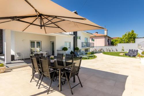 een patio met een tafel en stoelen en een parasol bij Casa de Monsanto | Lamego in Lamego