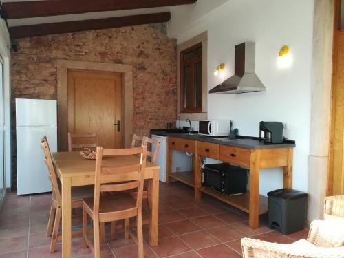 a kitchen with a wooden table and a dining room at Villa Rominha Alvaiázere - Casa do Canteiro in Alvaiázere