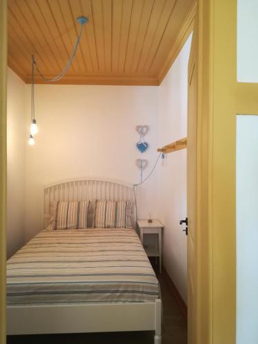a bedroom with a bed and a wooden ceiling at Villa Rominha Alvaiázere - Casa do Canteiro in Alvaiázere