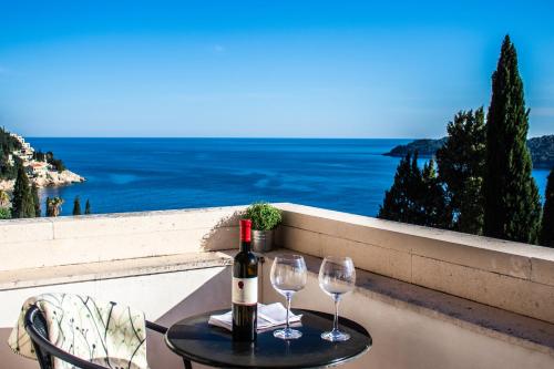 a table with two glasses and a bottle of wine at Villa Odak in Dubrovnik