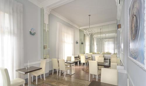 a dining room with tables and white chairs at Villa Grazia in Viareggio