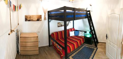 a bedroom with a bunk bed and a couch at La Casa Encantada del Bosque in Icod de los Vinos
