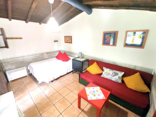 Habitación con cama, sofá y mesa. en Camping El Pinajarro en Hervás