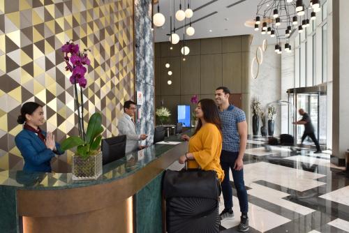 a group of people standing around a counter in a lobby at Swiss-Belsuites Admiral Juffair in Manama