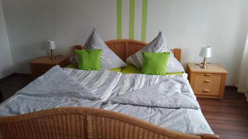 Una cama con almohadas verdes y blancas. en Landgasthof Zum Heidekrug, en Bad Orb