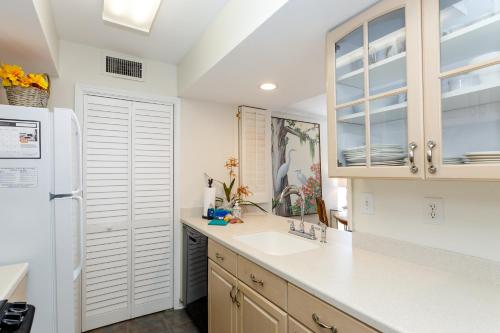 a kitchen with a sink and a refrigerator at 1313 Pelican Watch - Seabrook Island - Beachfront 5 Star Condo - Fido Friendly in Seabrook Island