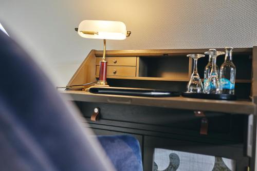 a desk with a lamp and some bottles on it at Boutiquehotel Liebesglück - adults only in Winterberg