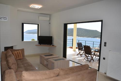 a living room with a couch and a television at Marmari MEGALI AMMOS MAISONETTE in Marmarion