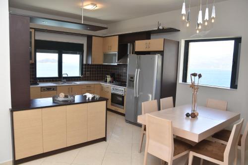 uma cozinha com uma mesa e um frigorífico em Marmari MEGALI AMMOS MAISONETTE em Marmari