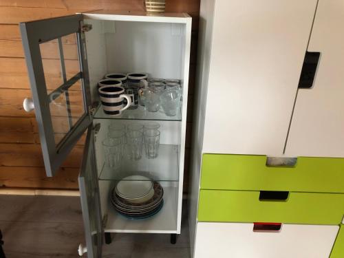 a refrigerator with plates and cups and dishes in it at Three Rooms stuga i stugby near National Park in Undenäs