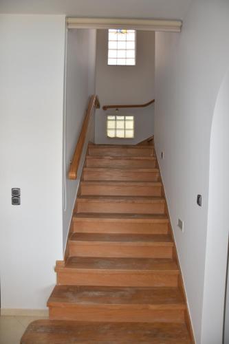 a staircase in a house with wooden floors and a window at Marmari MEGALI AMMOS MAISONETTE in Marmarion
