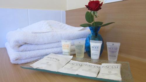 a table with a vase with a rose and someorative products at Dalby Mid Town Motor Inn in Dalby
