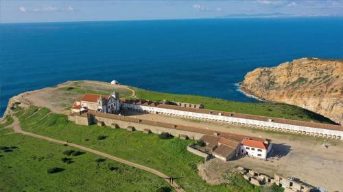 een luchtzicht op een kasteel op een heuvel naast de oceaan bij Alojamento Espigas in Azoia