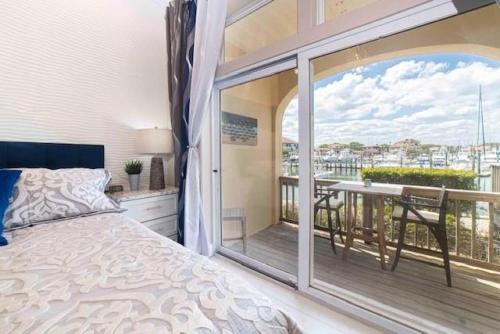 a bedroom with a bed and a balcony with a table at Inn at Camachee Harbor View 14 in Saint Augustine