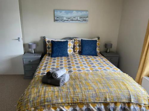 um quarto com uma cama grande e almofadas azuis em St Margarets Penthouse Apartment em Ryde