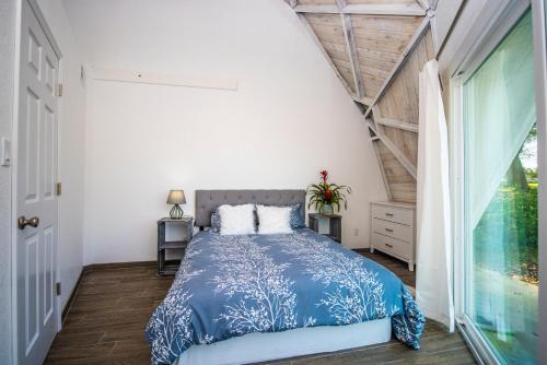 Un dormitorio con una cama azul y blanca y una ventana en ROOM 03 - Lake Sumner en Clermont