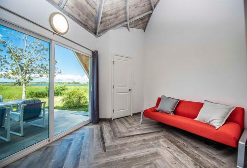 a living room with a red couch and a sliding glass door at STUDIO 01 - Lake Sumner in Clermont