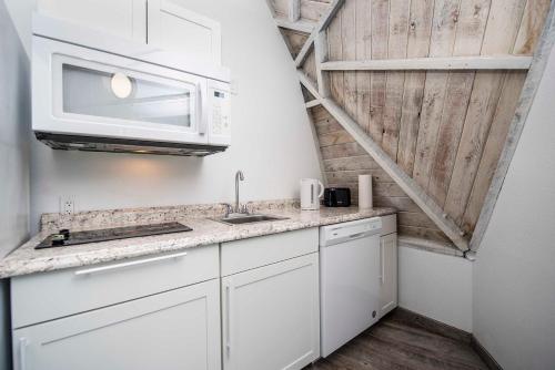 a white kitchen with a sink and a microwave at STUDIO 01 - Lake Sumner in Clermont