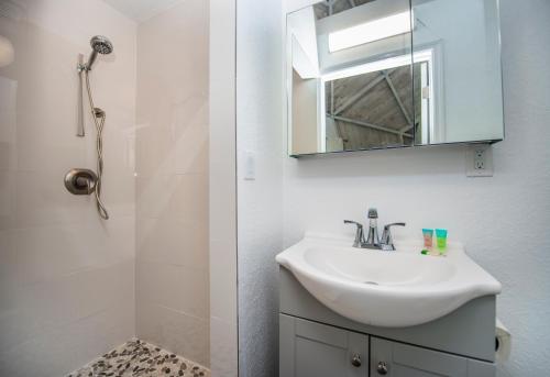 Baño blanco con lavabo y espejo en ROOM 03 - Lake Sumner en Clermont
