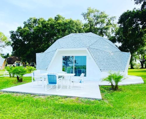 a circular house with a table and chairs in a field at ROOM 04 - Lake Sumner in Clermont