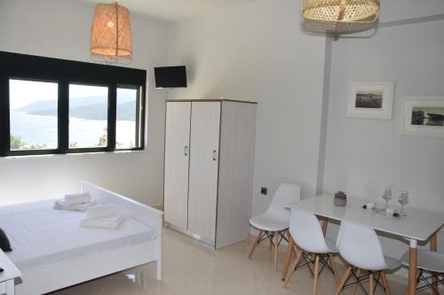 a white dining room with a white table and chairs at Marmari MEGALI AMMOS MAISONETTE in Marmarion