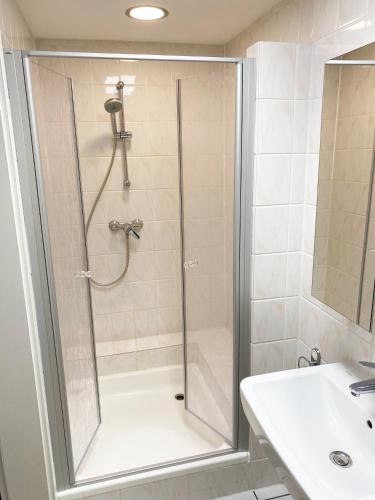 a shower with a glass door next to a sink at Ferienwohnungen Haus Gisela - Unterkunft Schlossberg in Bacharach