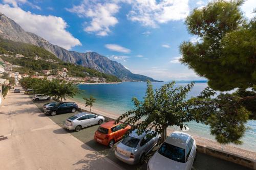 a group of cars parked on a beach next to the water at Beach Apartment Estelle in Podgora