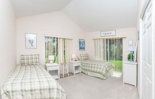 a bedroom with two beds and two windows at SWISS 61 - Lake Denise in Clermont