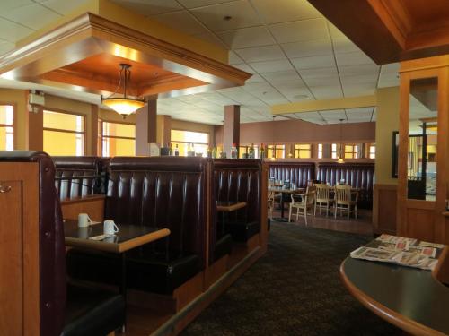 a restaurant with a dining room with tables and chairs at Athabasca Valley Inn & Suites in Hinton