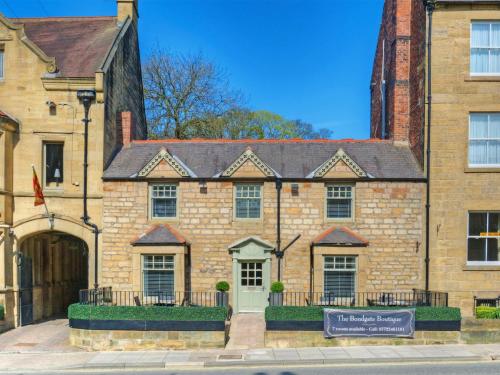 um grande edifício de tijolos com uma placa em frente em The Bondgate Boutique em Alnwick