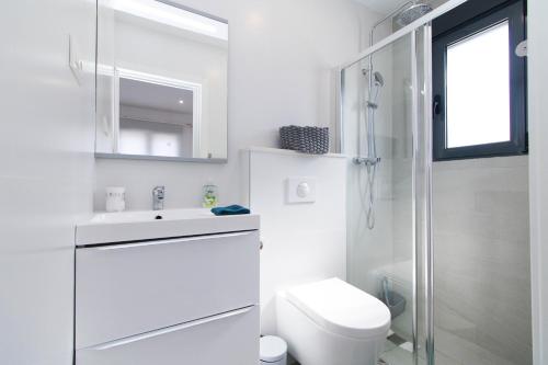 a white bathroom with a toilet and a sink at Arenas house in Torrevieja