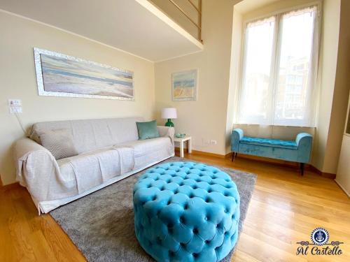 a living room with a couch and a blue ottoman at WELCOME RIVIERA - AL CASTELLO-VISTA MARE -ROMANTICO e CENTRALE a 20 METRI DAL MARE-toll parking at 15 euro per day to be booked in advance -subject to availability in Rapallo