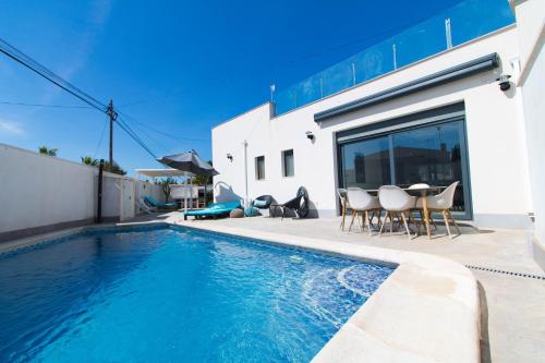 a swimming pool in front of a house at Arenas house in Torrevieja