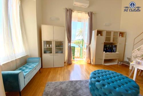 a living room with a blue couch and a large window at WELCOME RIVIERA - AL CASTELLO-VISTA MARE -ROMANTICO e CENTRALE a 20 METRI DAL MARE-toll parking at 15 euro per day to be booked in advance -subject to availability in Rapallo
