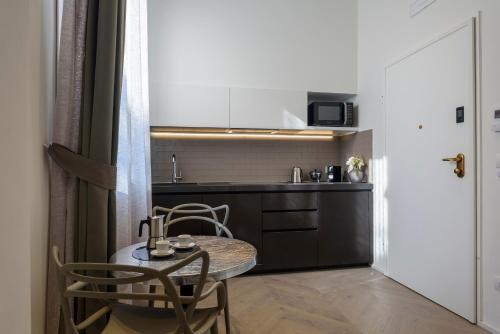 a small kitchen with a table and two chairs at Mysuiteshome Apartments in Bologna