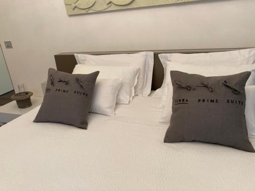 a bed with white pillows and a white bed with three pillows at Terra Prime Suite in Riomaggiore