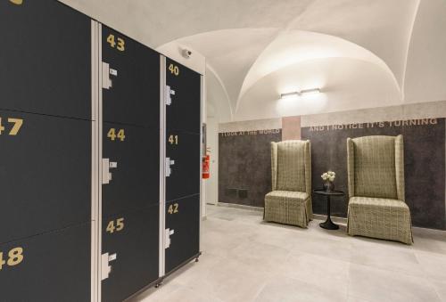 a locker room with two chairs and a wall with numbers at Mysuiteshome Apartments in Bologna
