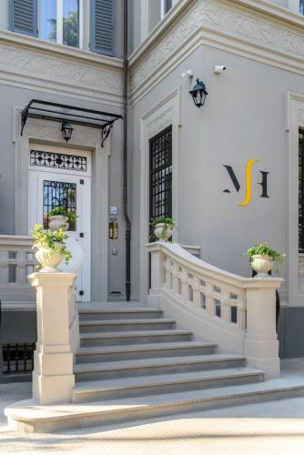 a white building with stairs leading to the front door at Mysuiteshome Apartments in Bologna