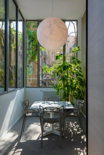a table and chairs on a balcony with a potted plant at Mysuiteshome Apartments in Bologna