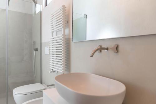 a bathroom with a sink and a toilet and a mirror at Il Sogno delle Benedettine in Ostuni
