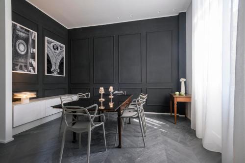 a dining room with black walls and a table and chairs at Mysuiteshome Apartments in Bologna