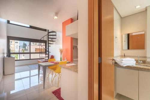 a kitchen with a counter and a dining room at Apartamento Lugar Perfeito Duplex Casemiro 199 in Porto Alegre