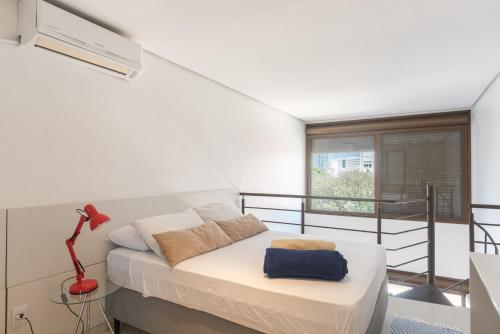a bedroom with a bed and a balcony at Apartamento Lugar Perfeito Duplex Casemiro 199 in Porto Alegre