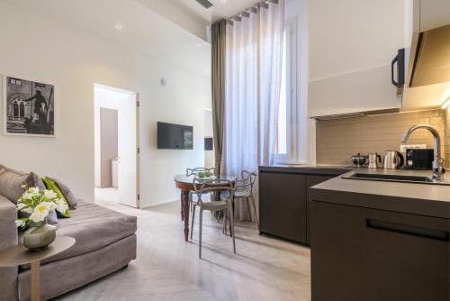 a kitchen and living room with a couch and a table at Mysuiteshome Apartments in Bologna