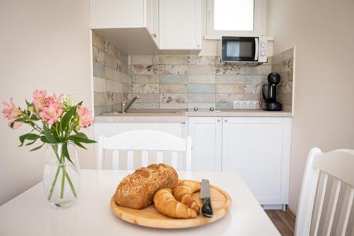 a table with a plate of bread and a vase of flowers at Szigligeti Mandula Kert Vendégház in Szigliget