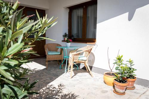 a patio with a table and chairs and plants at Szigligeti Mandula Kert Vendégház in Szigliget