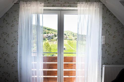 a window with a view of a green field at Szigligeti Mandula Kert Vendégház in Szigliget