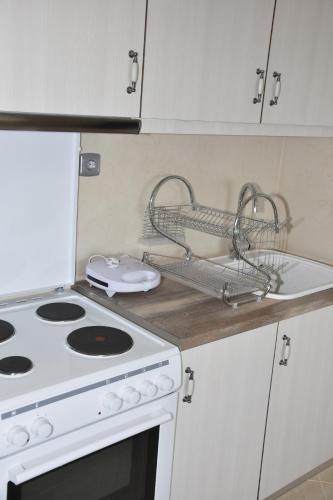 a kitchen counter with a white stove and a sink at Marmari MEGALI AMMOS MAISONETTE in Marmarion
