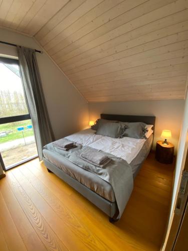 een slaapkamer met een groot bed en een houten plafond bij Marina Lubkowo Dom Czarna Perła in Lubkowo