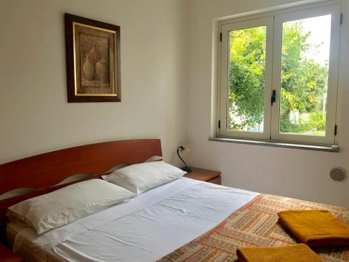 ein Schlafzimmer mit einem Bett und einem Fenster in der Unterkunft San Rocco one bed Apartments 4A1 9 in Isca sullo Ionio